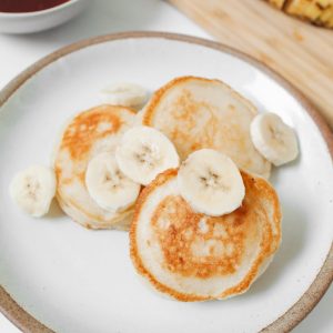 photo of pancakes with banana on white ceramic plate