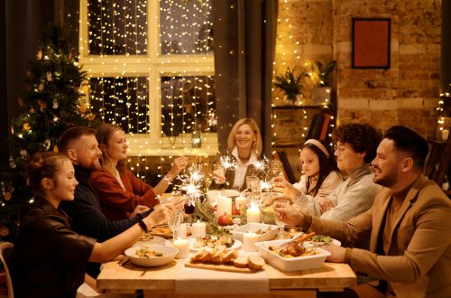 family celebrating christmas while holding burning sparklers