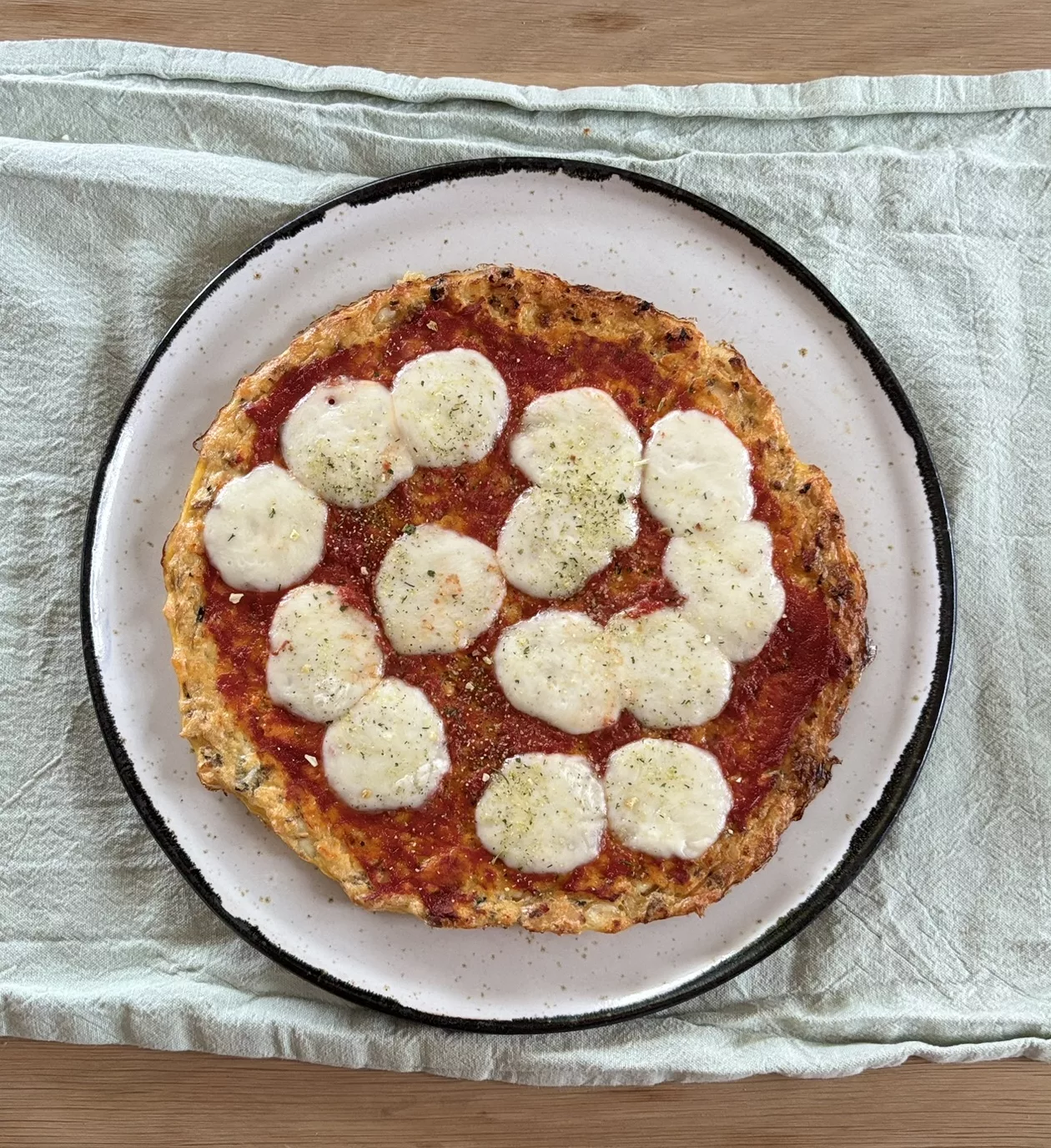 Pizza mit Thunfisch-Frischkäse Boden, fertig belegt und gebacken mit Tomaten und Mozzarella.
